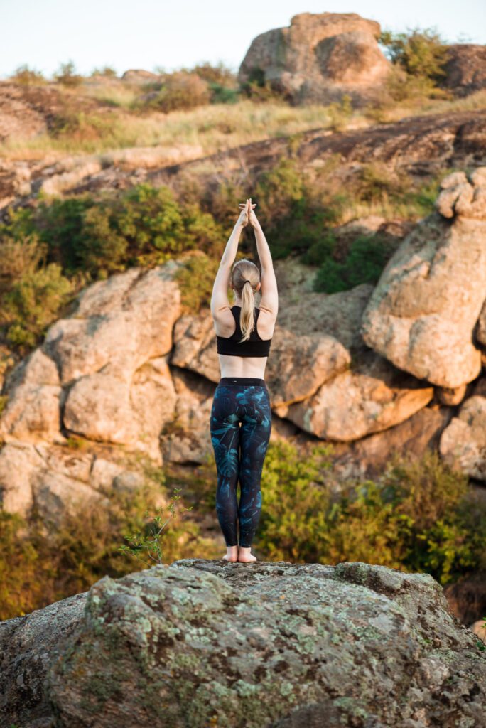 young sportive woman training yoga asanas rock canyon scaled 1