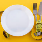 cutlery white plate with measuring tape yellow concept weight loss diet scaled 1