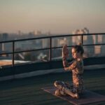 woman doing yoga roof skyscraper big city scaled 1
